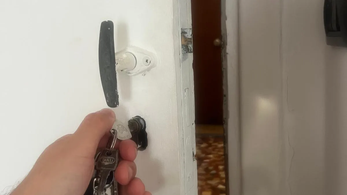 Test de la clé dans le cylindre d'une porte d'entrée ancienne, porte entrouverte