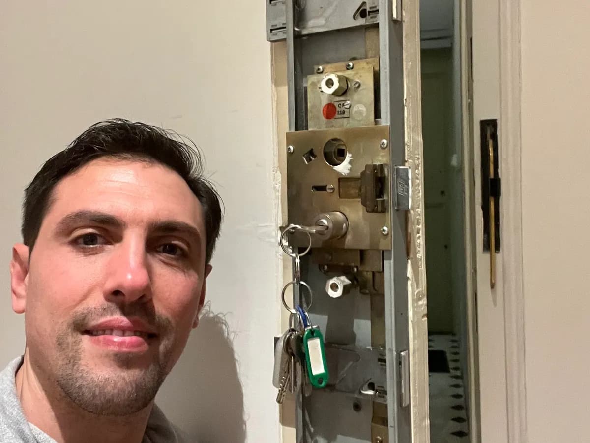 Benoît, artisan serrurier, à côté d'un mécanisme de porte à Nice