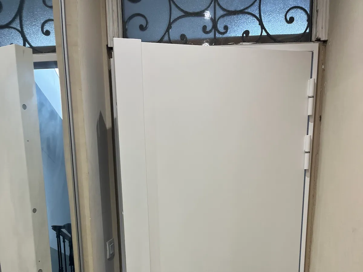 Porte neuve installée sous une imposte à ferronnerie, à Nice